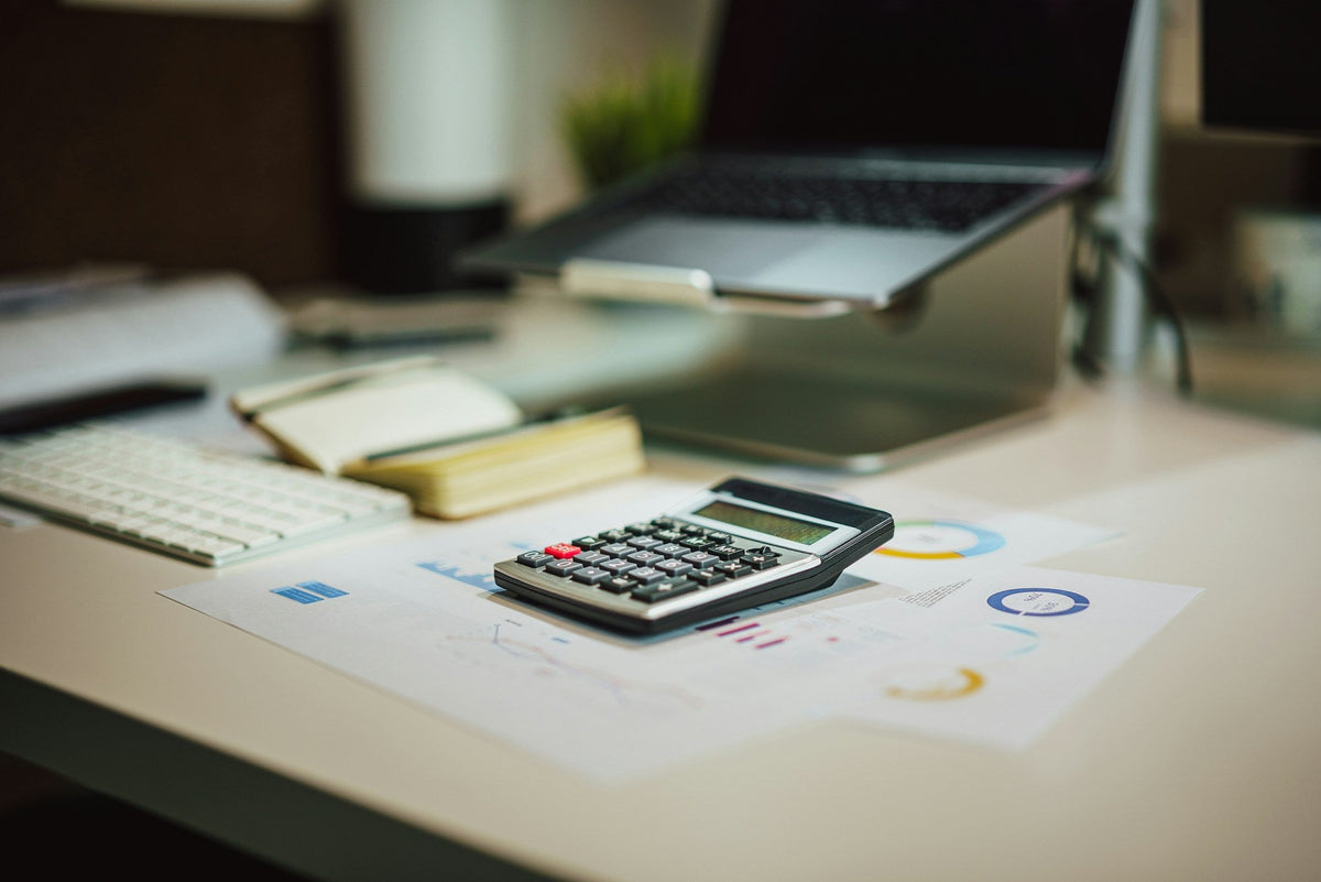Calculator and printed charts on a desk, used to work out firework tax before checkout