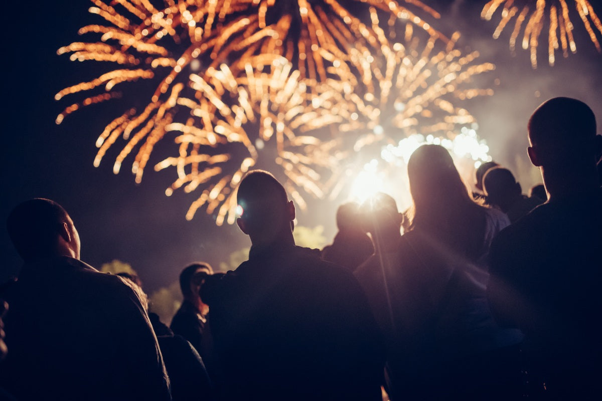 People backlit by fireworks brought wholesale for even companies.