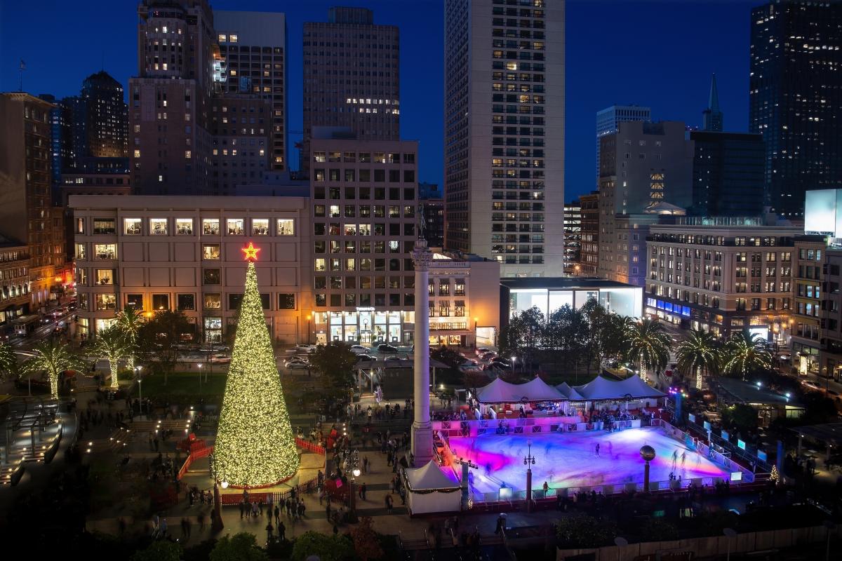 City square decorated for Christmas with a large tree and holiday lights at night, showing why fireworks on Christmas Eve are part of seasonal celebrations