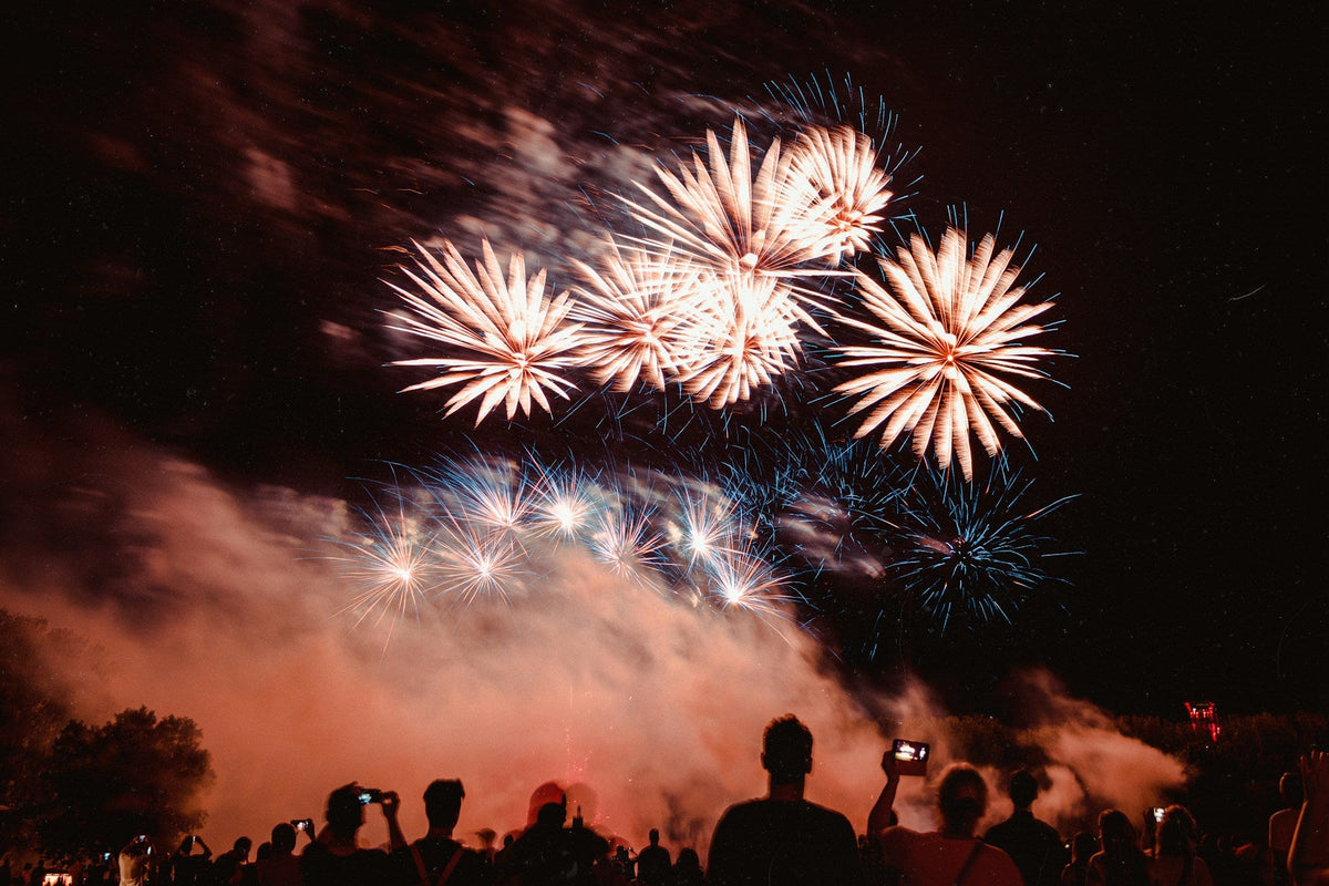 How to become a fireworks technician showing a professional fireworks display bursting over a crowd of spectators at night (1)